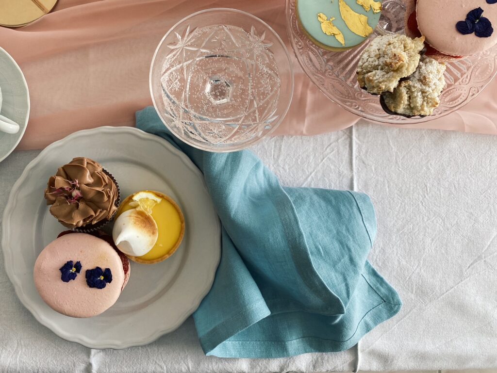 Ein Sweet Table in Pastell-Farben, angerichtet auf einem rosafarbenen Tu