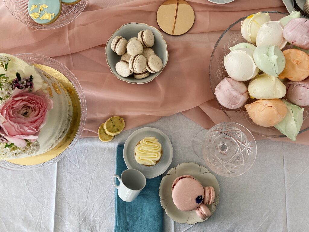 Ein Sweet Table in Pastell-Farben, angerichtet auf einem rosafarbenen Tu